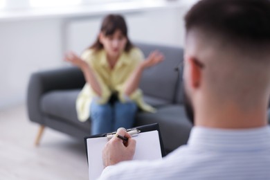 Photo of Professional psychologist working with patient in office, selective focus