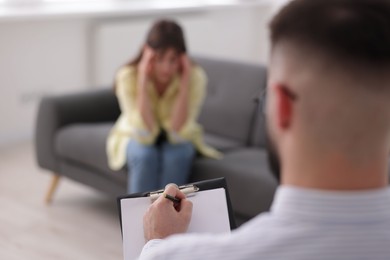 Photo of Professional psychologist working with patient in office, selective focus
