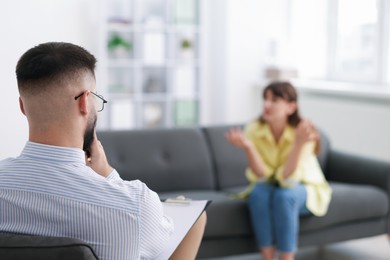 Photo of Professional psychologist working with patient in office, selective focus