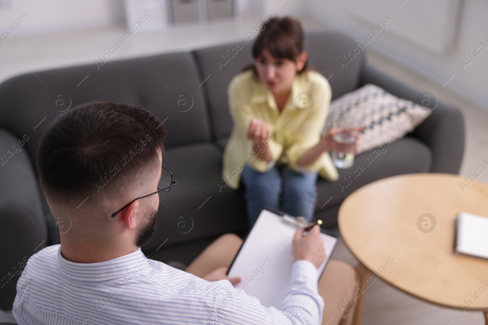 Photo of Professional psychologist working with patient in office, selective focus