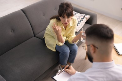 Photo of Professional psychologist working with patient in office, above view