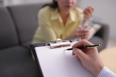 Photo of Professional psychologist working with patient in office, selective focus