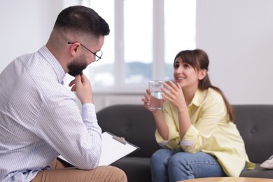 Photo of Professional psychologist working with patient in office, selective focus