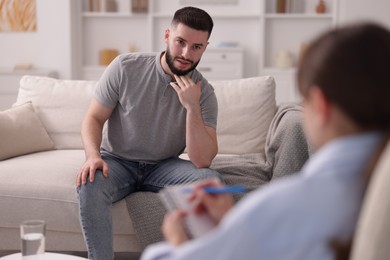Photo of Professional psychologist working with patient in office, selective focus