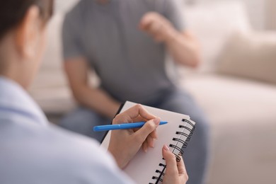 Photo of Professional psychologist working with patient in office, selective focus