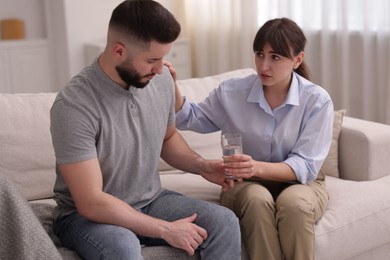 Photo of Psychologist supporting patient during therapy session on sofa in office