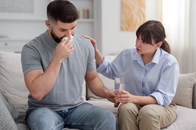 Photo of Psychologist supporting patient during therapy session on sofa in office