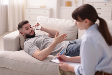 Photo of Professional psychologist working with patient in office, selective focus