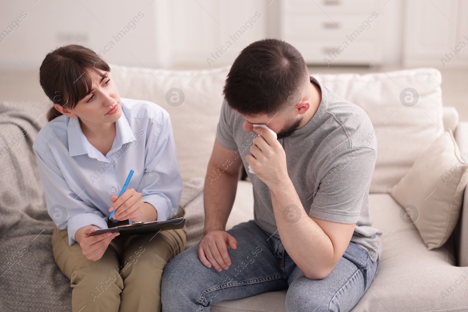 Photo of Professional psychologist working with patient on sofa in office