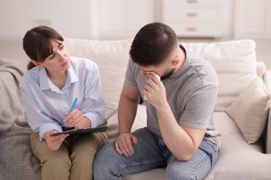 Photo of Professional psychologist working with patient on sofa in office