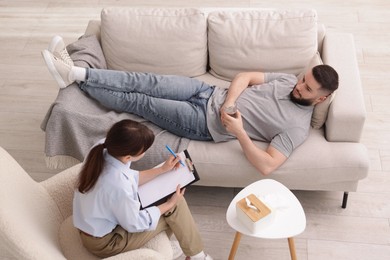 Photo of Professional psychologist working with patient in office, above view