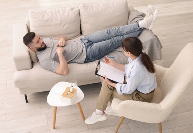 Photo of Professional psychologist working with patient in office, above view