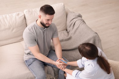 Photo of Psychologist supporting patient during therapy session in office, above view