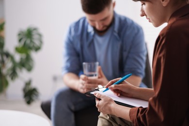 Photo of Professional psychologist working with patient in office, selective focus