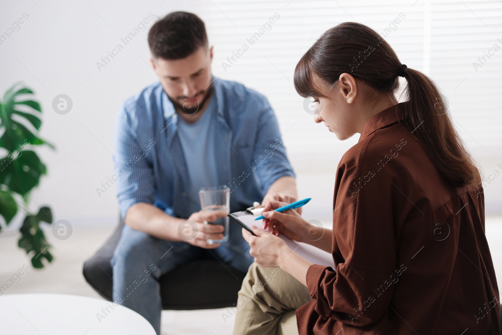 Photo of Professional psychologist working with patient in office, selective focus