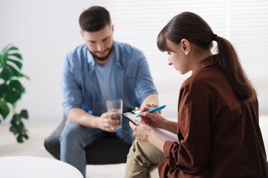 Photo of Professional psychologist working with patient in office, selective focus