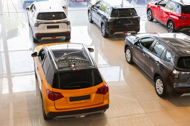 Photo of Many luxury new cars in salon. Modern transport