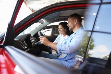 Photo of Happy family sitting inside new car. Luxury vehicle