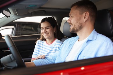 Photo of Happy family sitting inside new car. Luxury vehicle
