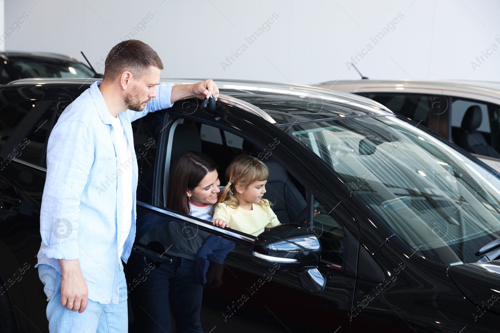Photo of Happy family and new car in salon