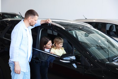 Photo of Happy family and new car in salon