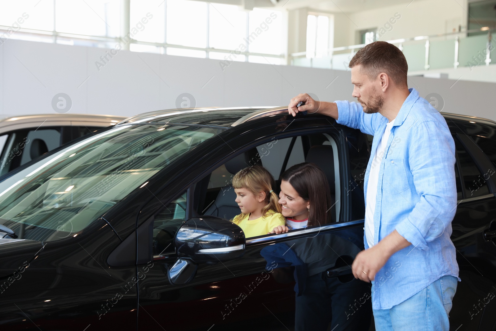 Photo of Happy family and new car in salon