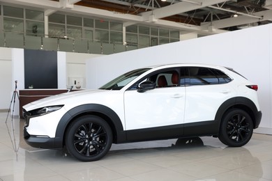 Photo of Modern white car in salon. Luxury vehicle