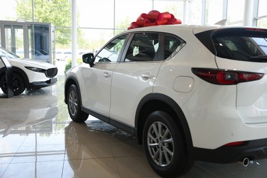 Photo of Modern white cars in salon. Luxury vehicle