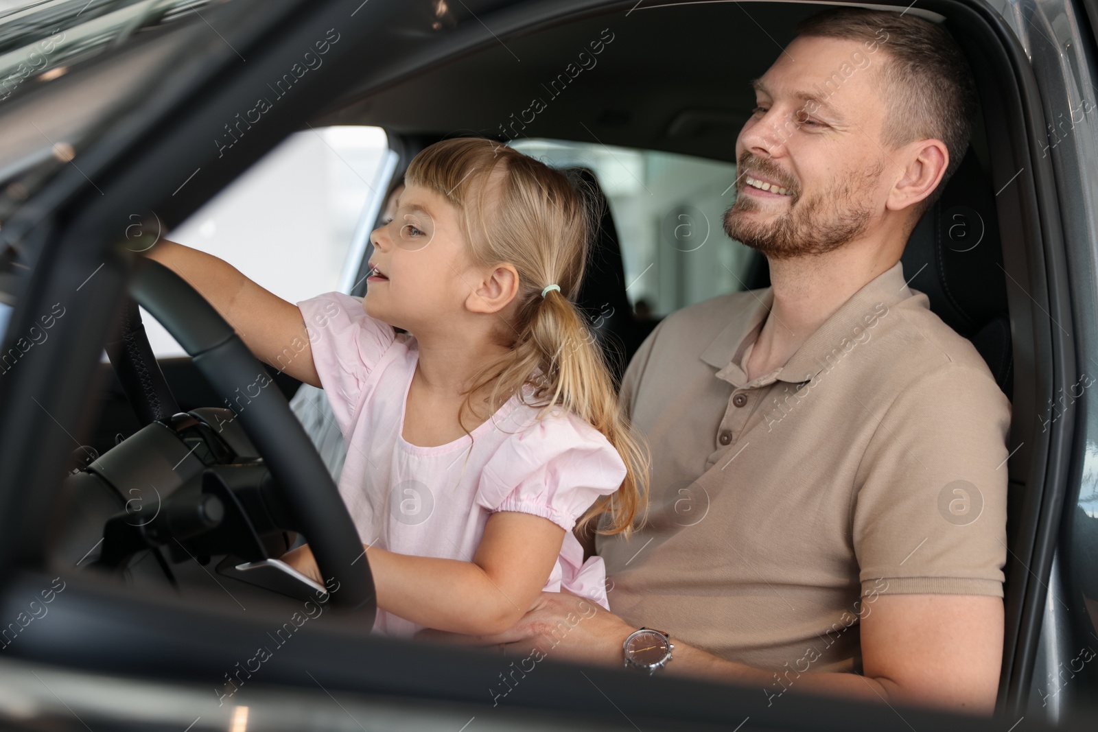 Photo of Happy family sitting inside new car. Luxury vehicle