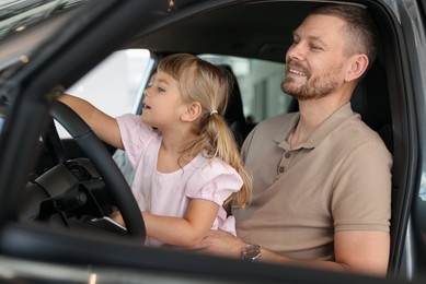 Photo of Happy family sitting inside new car. Luxury vehicle