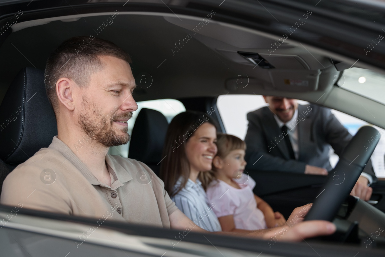 Photo of Happy family inside new car and salesman, selective focus