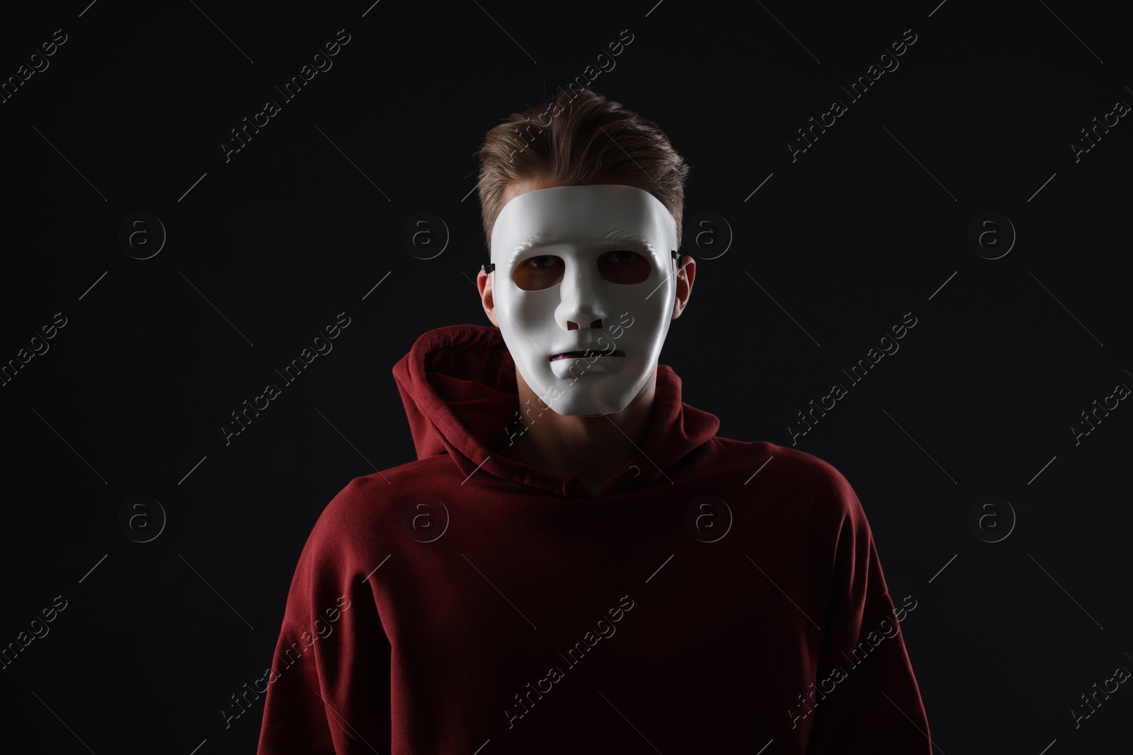 Photo of Anonymity. Man wearing mask on dark background