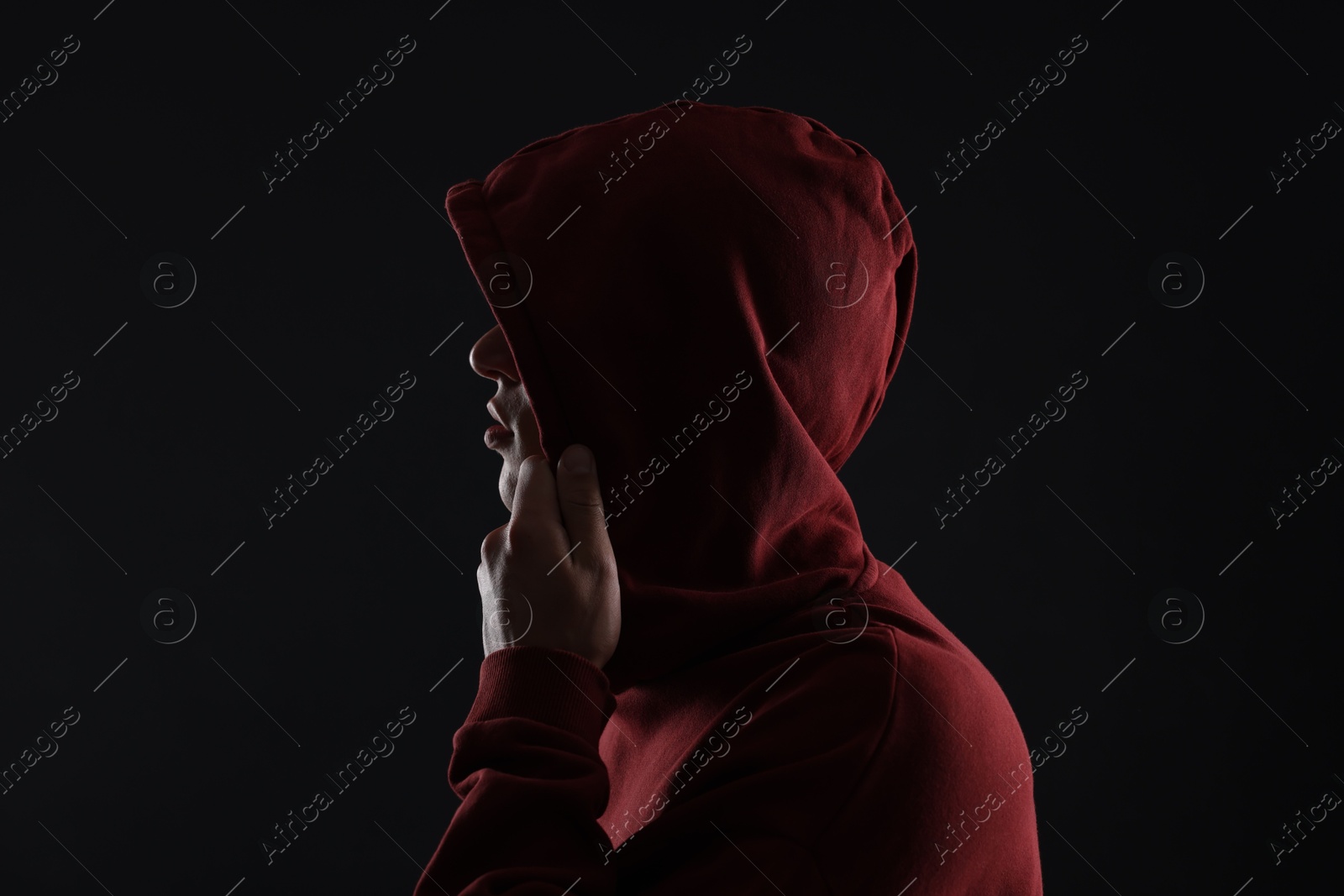 Photo of Anonymity. Man hiding his face in darkness