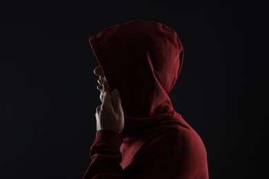 Photo of Anonymity. Man hiding his face in darkness