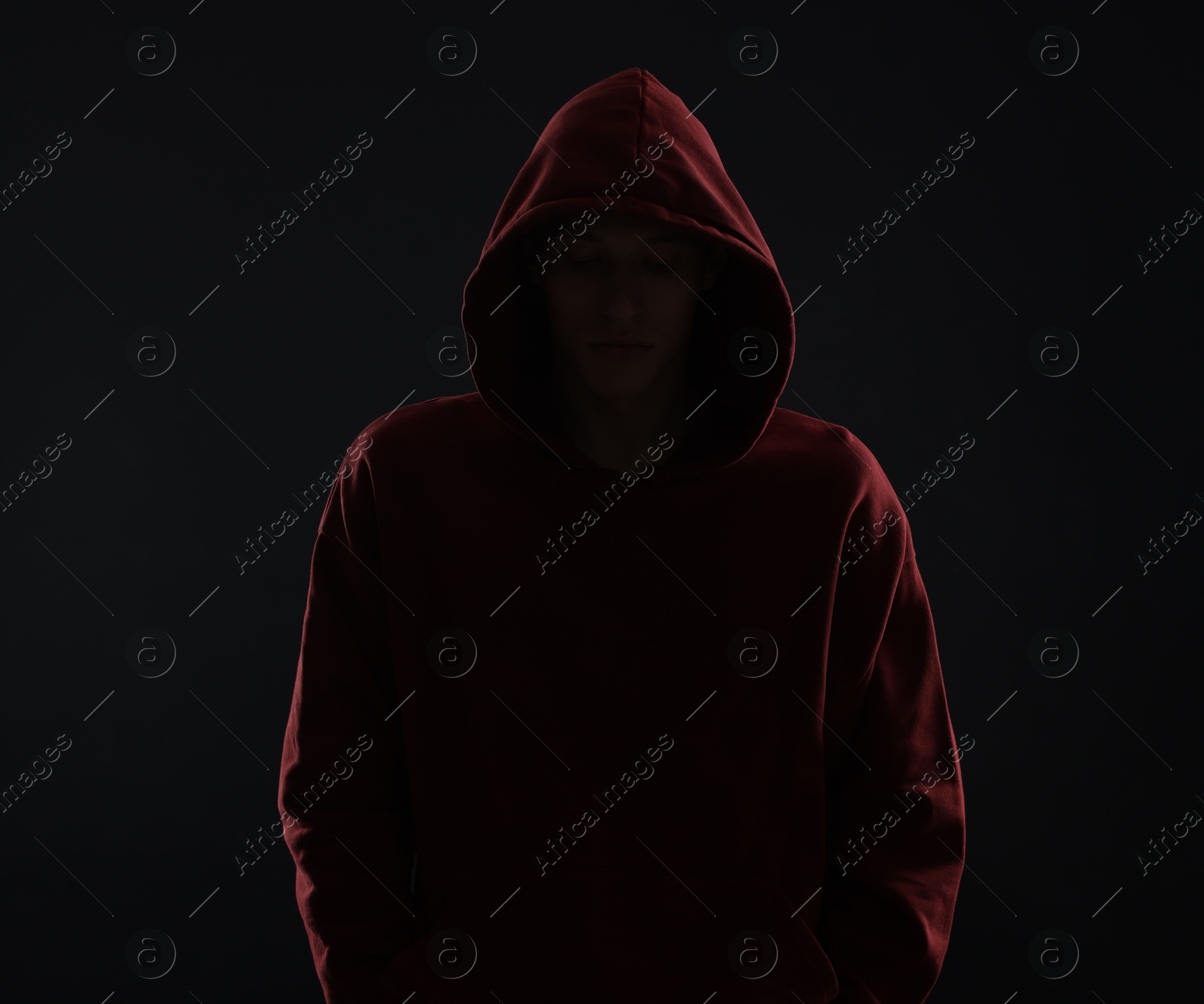 Photo of Anonymity. Man hiding his face in darkness