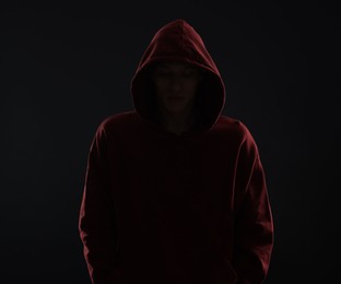 Photo of Anonymity. Man hiding his face in darkness