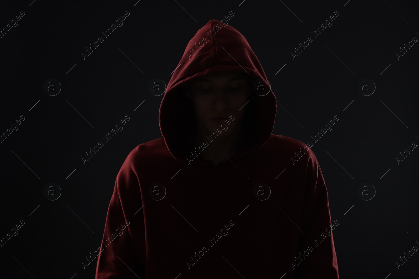 Photo of Anonymity. Man hiding his face in darkness