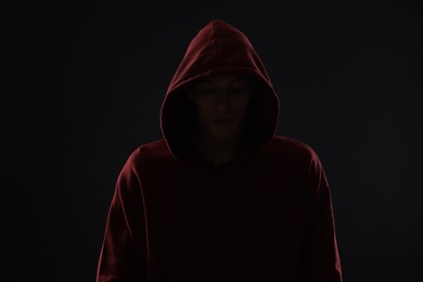 Photo of Anonymity. Man hiding his face in darkness