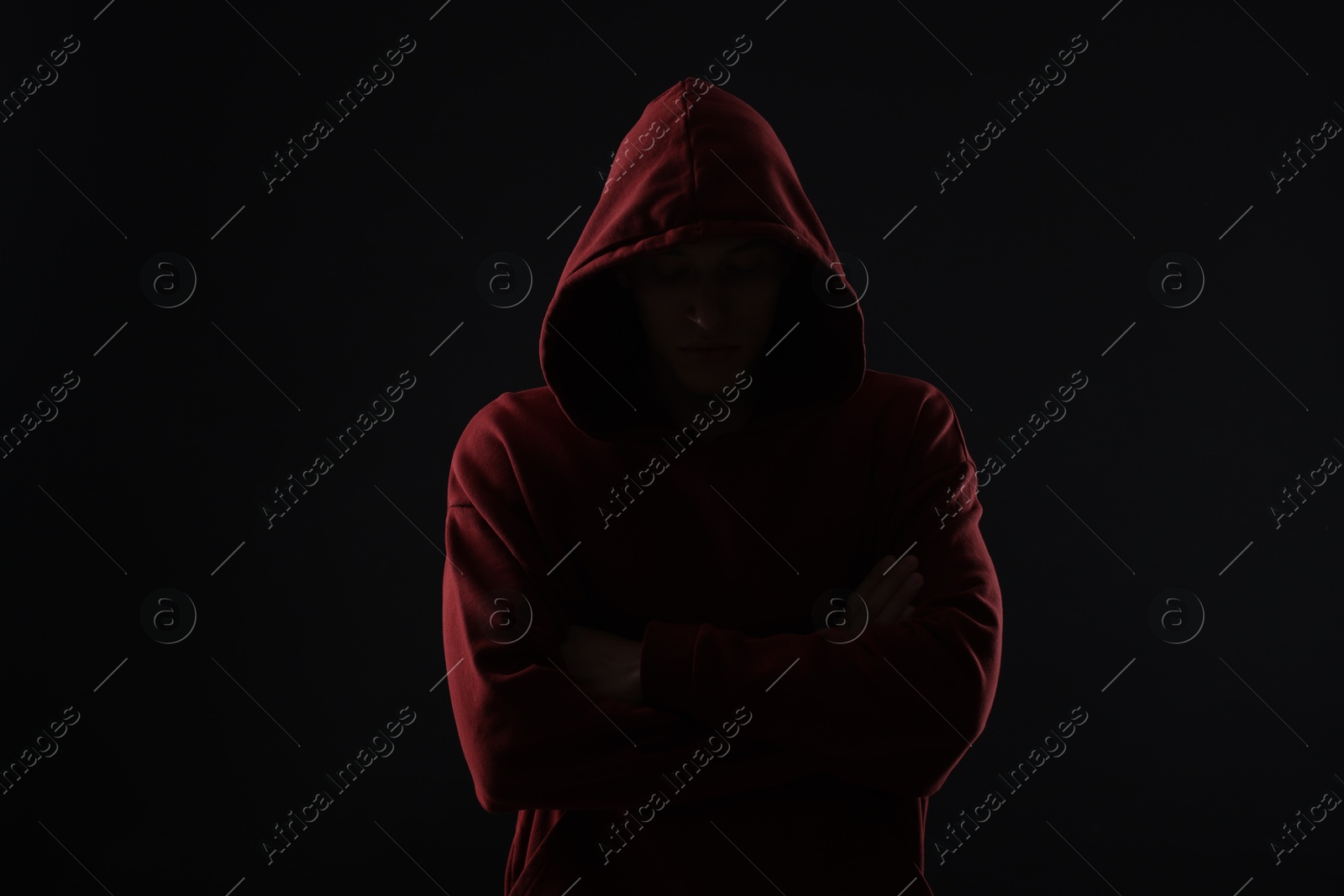 Photo of Anonymity. Man hiding his face in darkness