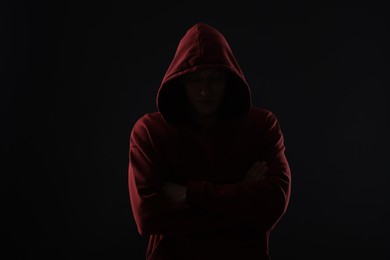 Photo of Anonymity. Man hiding his face in darkness