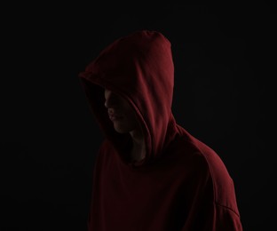 Photo of Anonymity. Man hiding his face in darkness