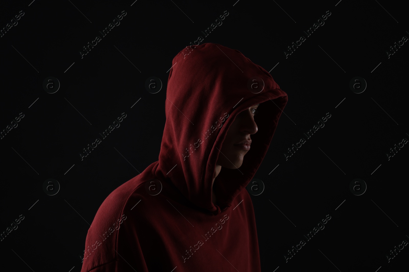 Photo of Anonymity. Man hiding his face in darkness