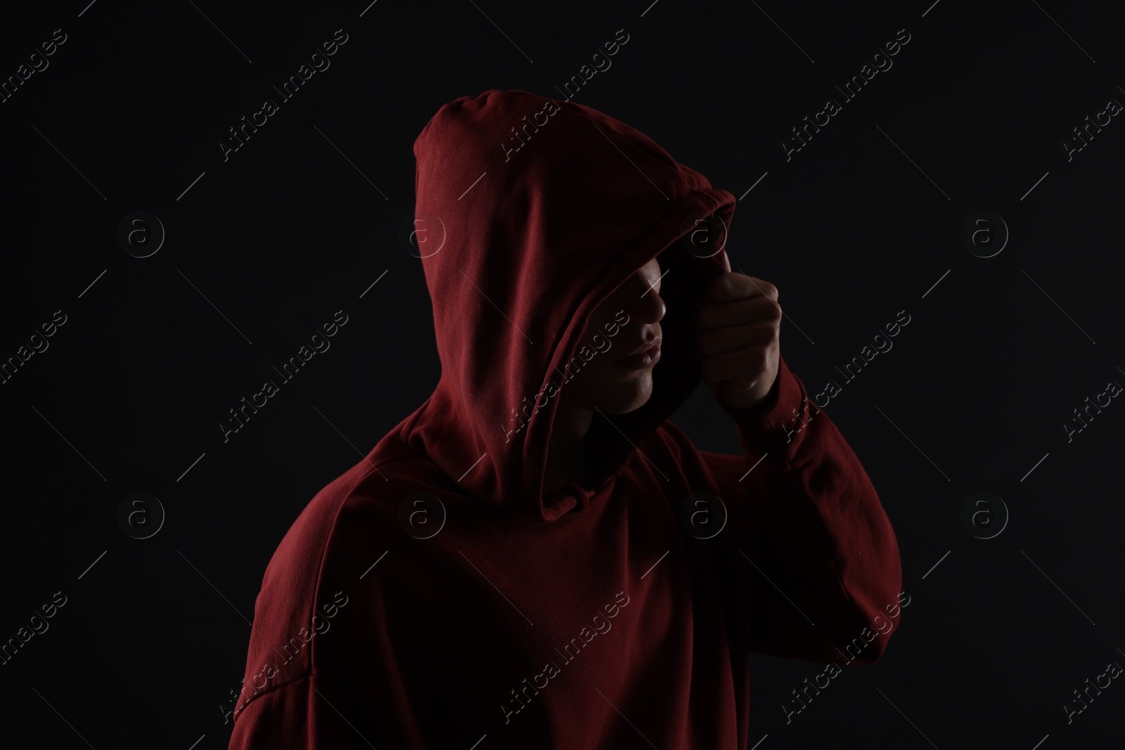 Photo of Anonymity. Man hiding his face in darkness