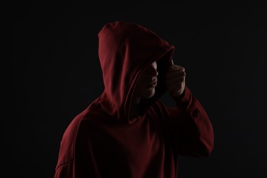 Photo of Anonymity. Man hiding his face in darkness