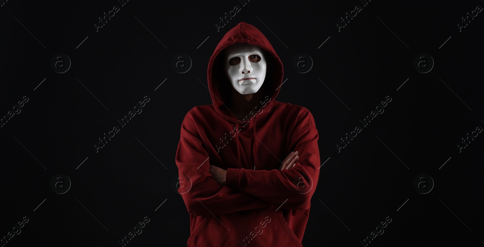 Photo of Anonymity. Man wearing mask on dark background