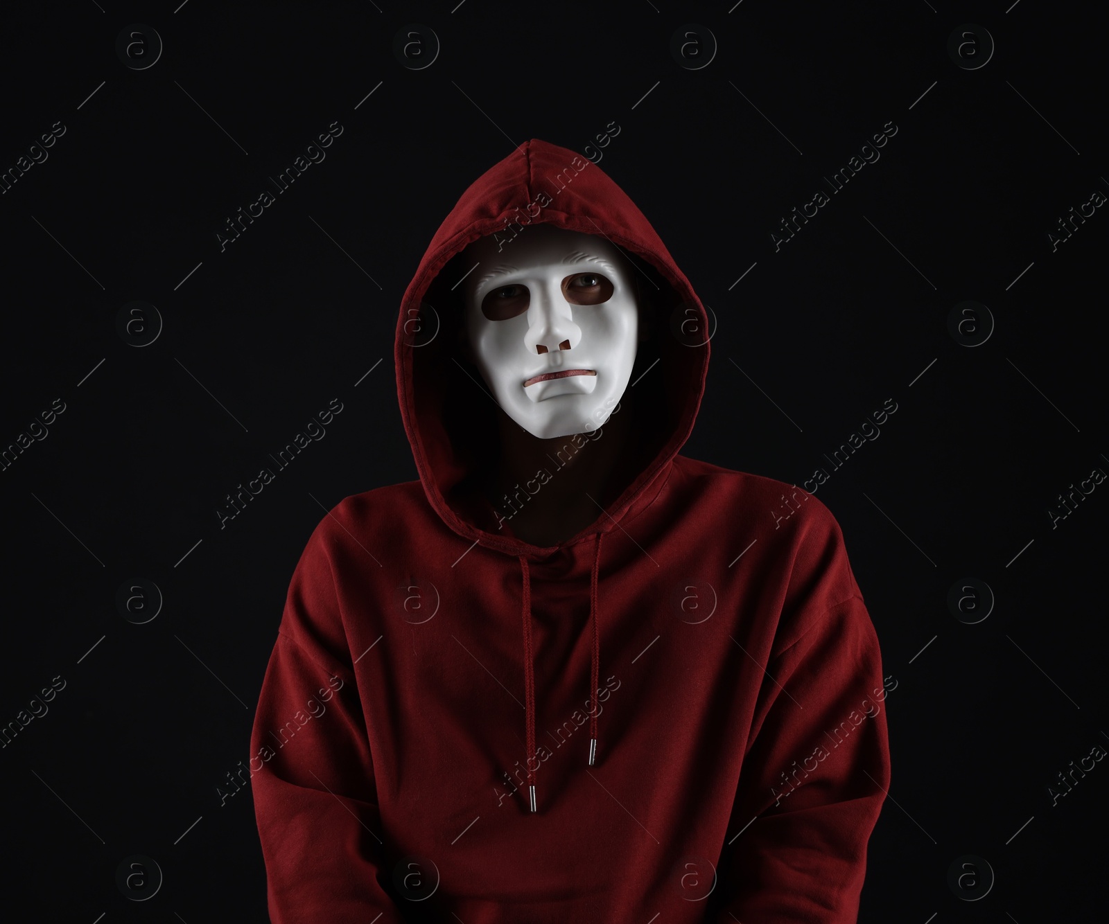 Photo of Anonymity. Man wearing mask on dark background