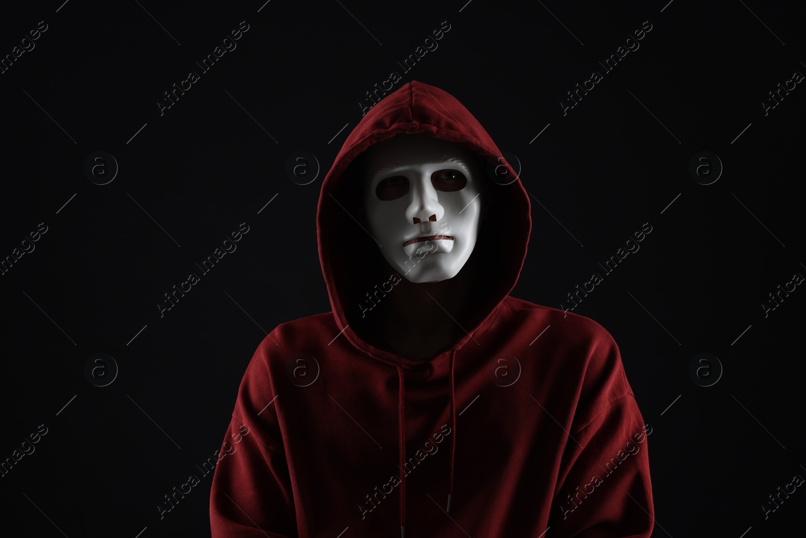 Photo of Anonymity. Man wearing mask on dark background