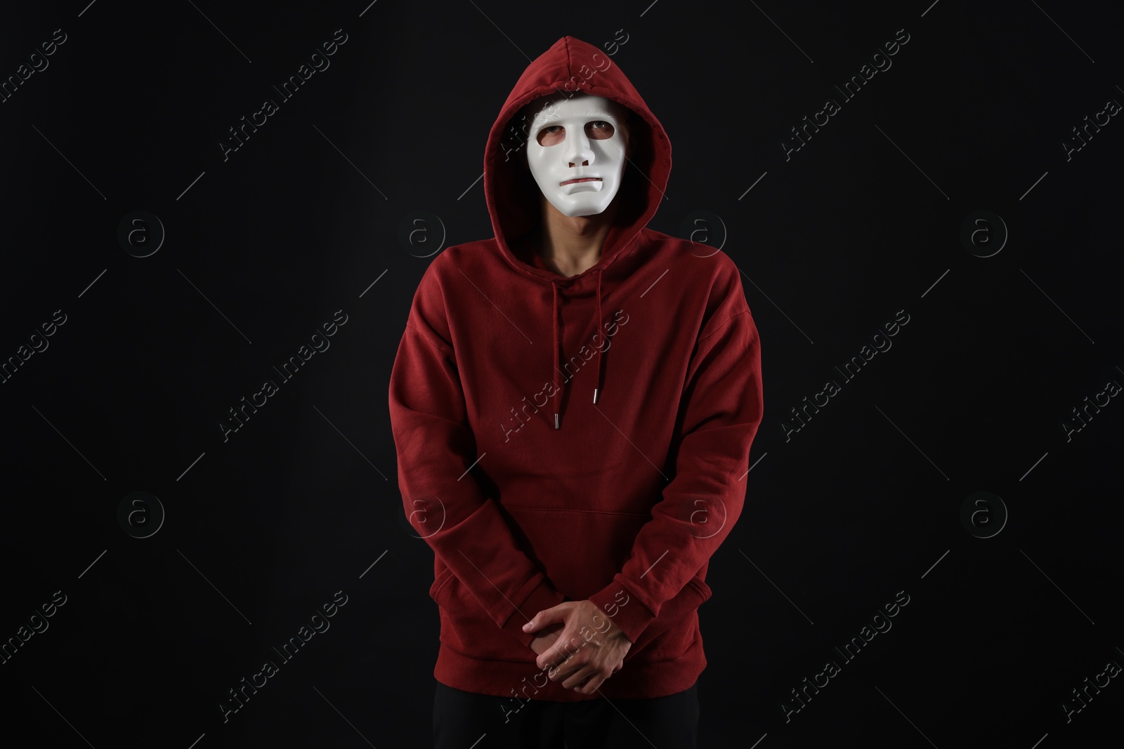 Photo of Anonymity. Man wearing mask on dark background
