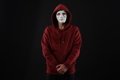 Photo of Anonymity. Man wearing mask on dark background