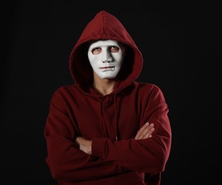 Photo of Anonymity. Man wearing mask on dark background